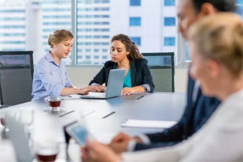 Des professionnels en réunion dans une salle moderne, illustrant les enjeux de recrutement dans le secteur numérique.

