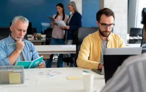 Deux commerciaux concentrés dans un open space illustrant la digitalisation des forces de vente Orange.