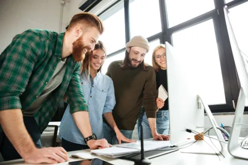 Quatre jeunes professionnels collaborent autour d’un bureau dans un environnement lumineux, illustrant l’innovation, l’esprit d’équipe et le dynamisme de l’emploi tech en Tunisie.
