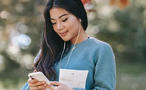 Jeune femme utilisant son smartphone, illustrant la connectivité mobile et les réseaux auto-adaptatifs

